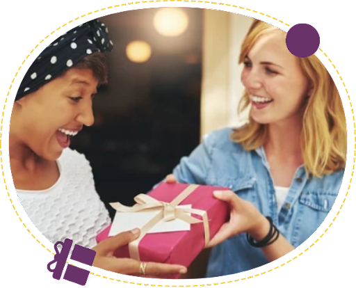 Two women are holding a gift box and smiling.